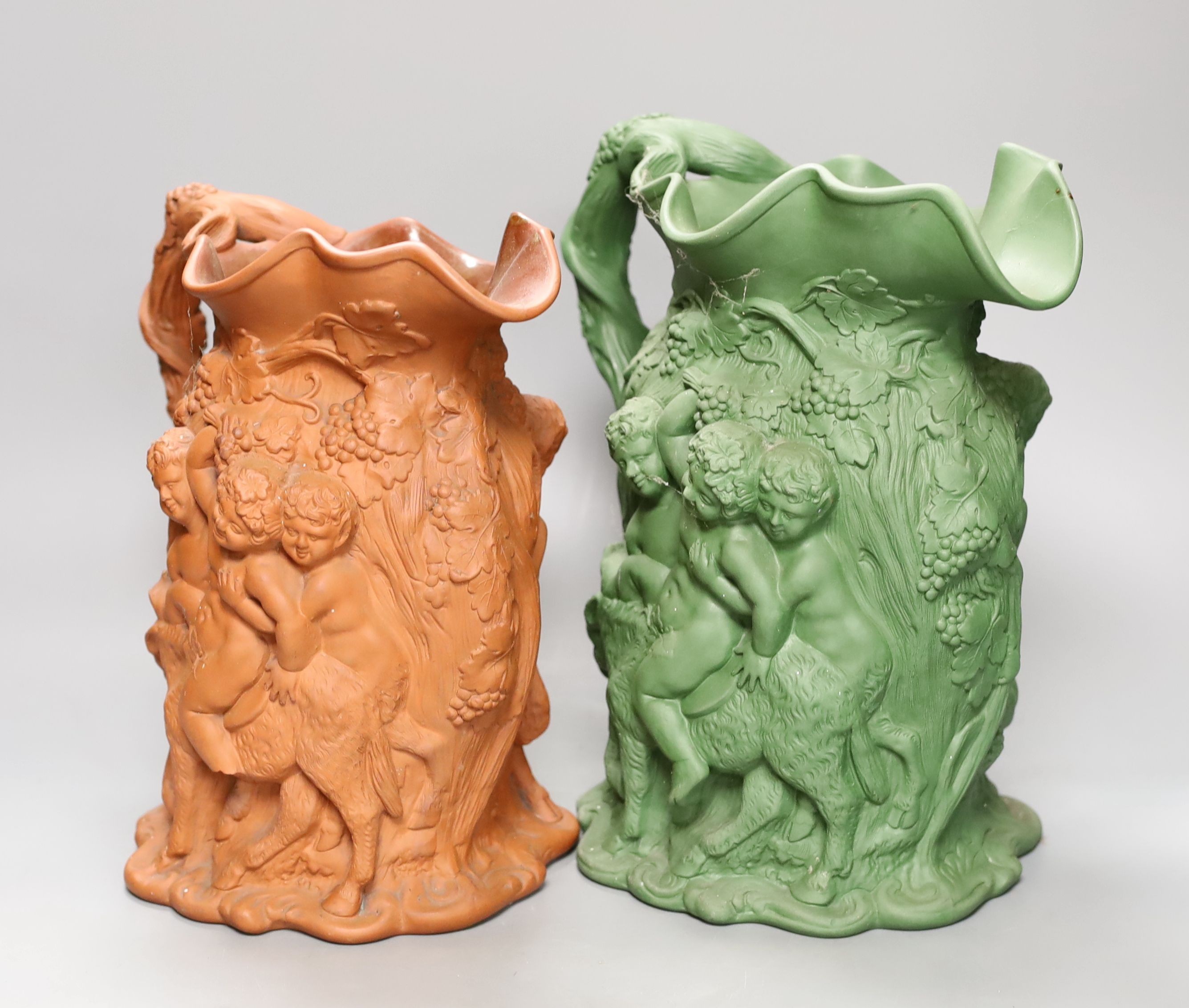 Two early 19th century terracotta Bacchanalian jugs, one green glazed 28cm